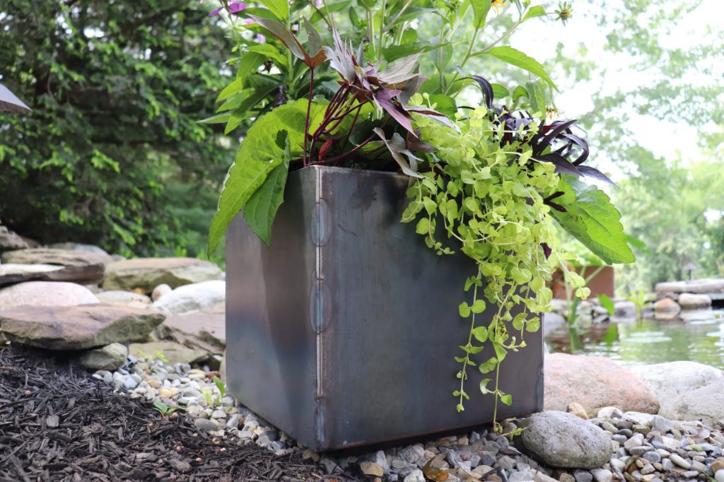 metal planters add industrial flair to garden spaces
