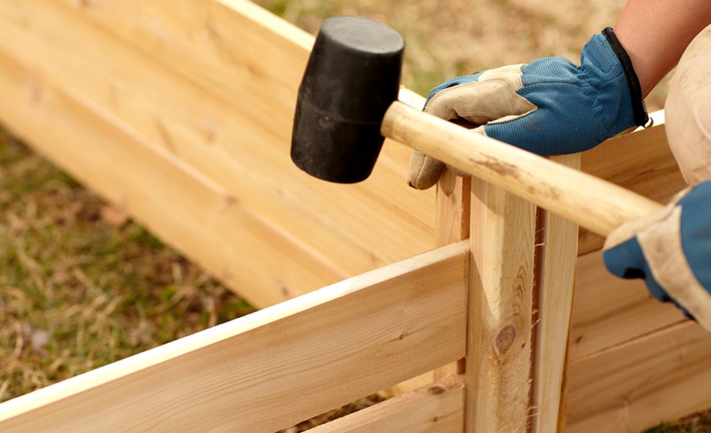 person building a raised garden bed frame