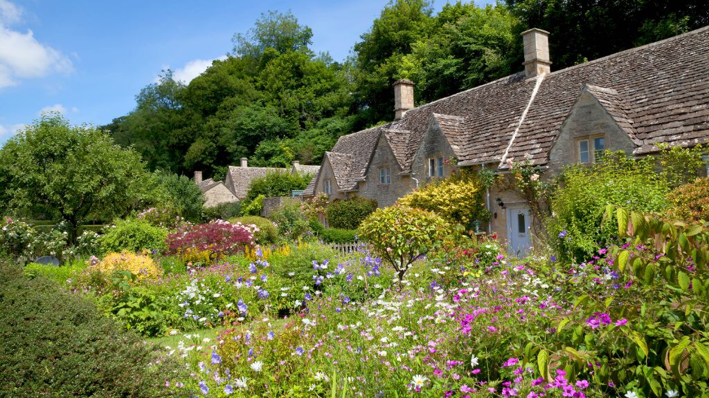 photo of a charming cottage garden path with overflowing flowerbeds